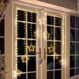 Warm white LED star curtain lights with hanging star-shaped bulbs displayed on a set of double French doors at night Christmas